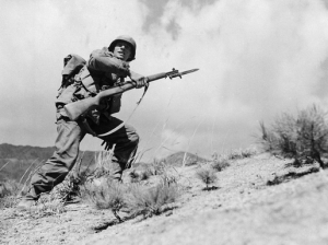 Taking the hill. Pfc. John J. Allen of Company E in the 25th Infantry Division leads his men in attack on the west central front in Korea, March 30, 1951.